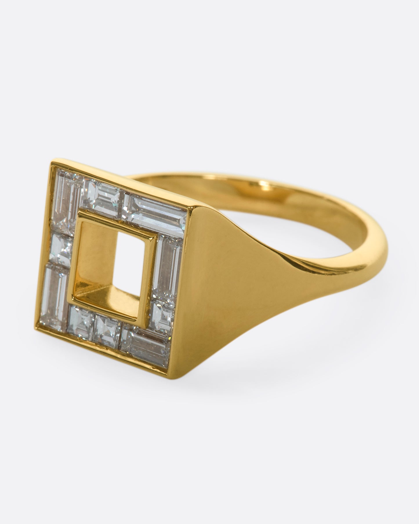 A close up of the left side of a square ring set with baguette diamonds.