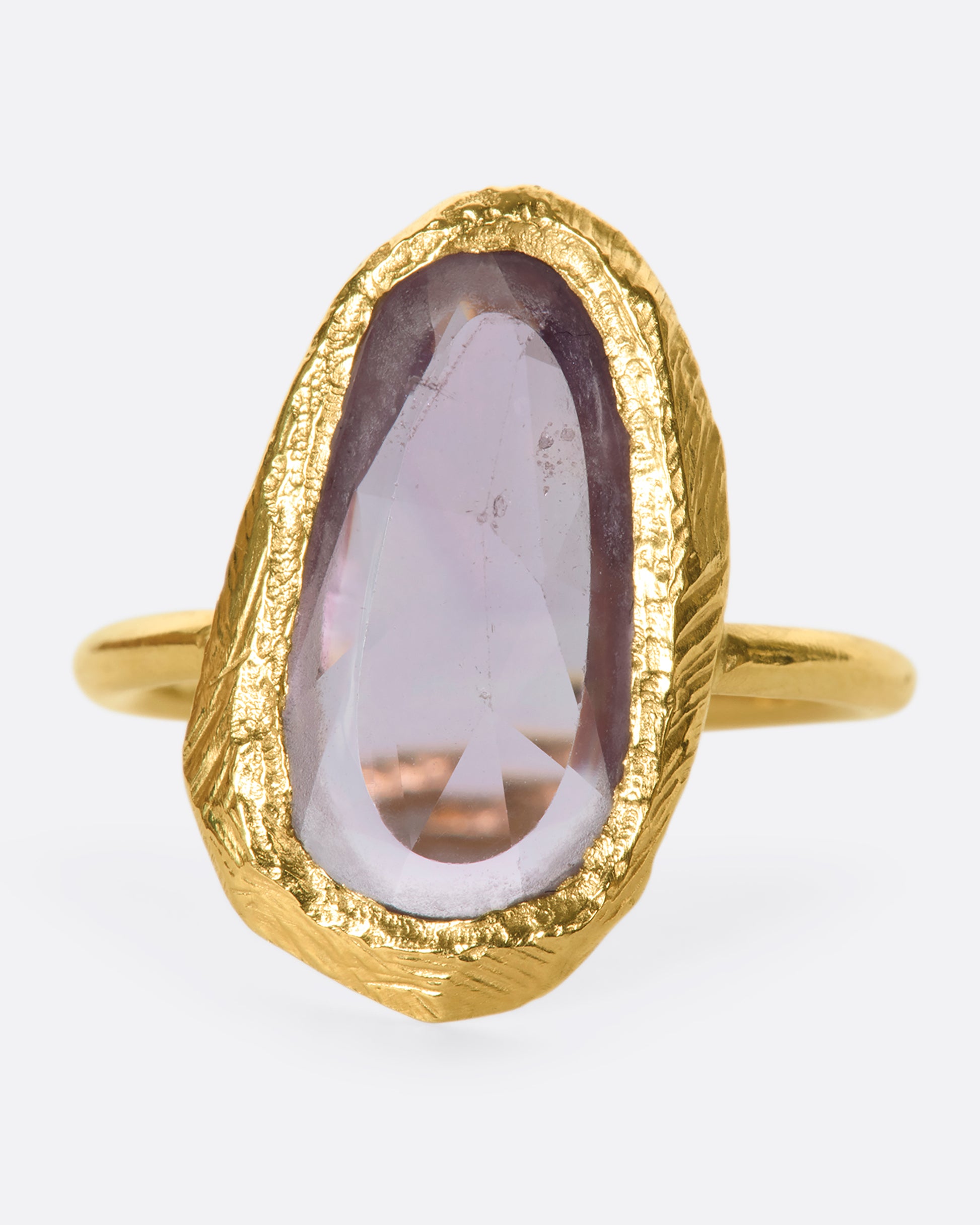 This truly unique freeform, rose-cut purple sapphire is nestled in a hand-carved 18k gold bezel setting