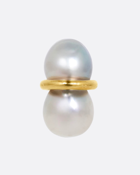 A pearl earring with a gold loop around the middle, shown from the front.