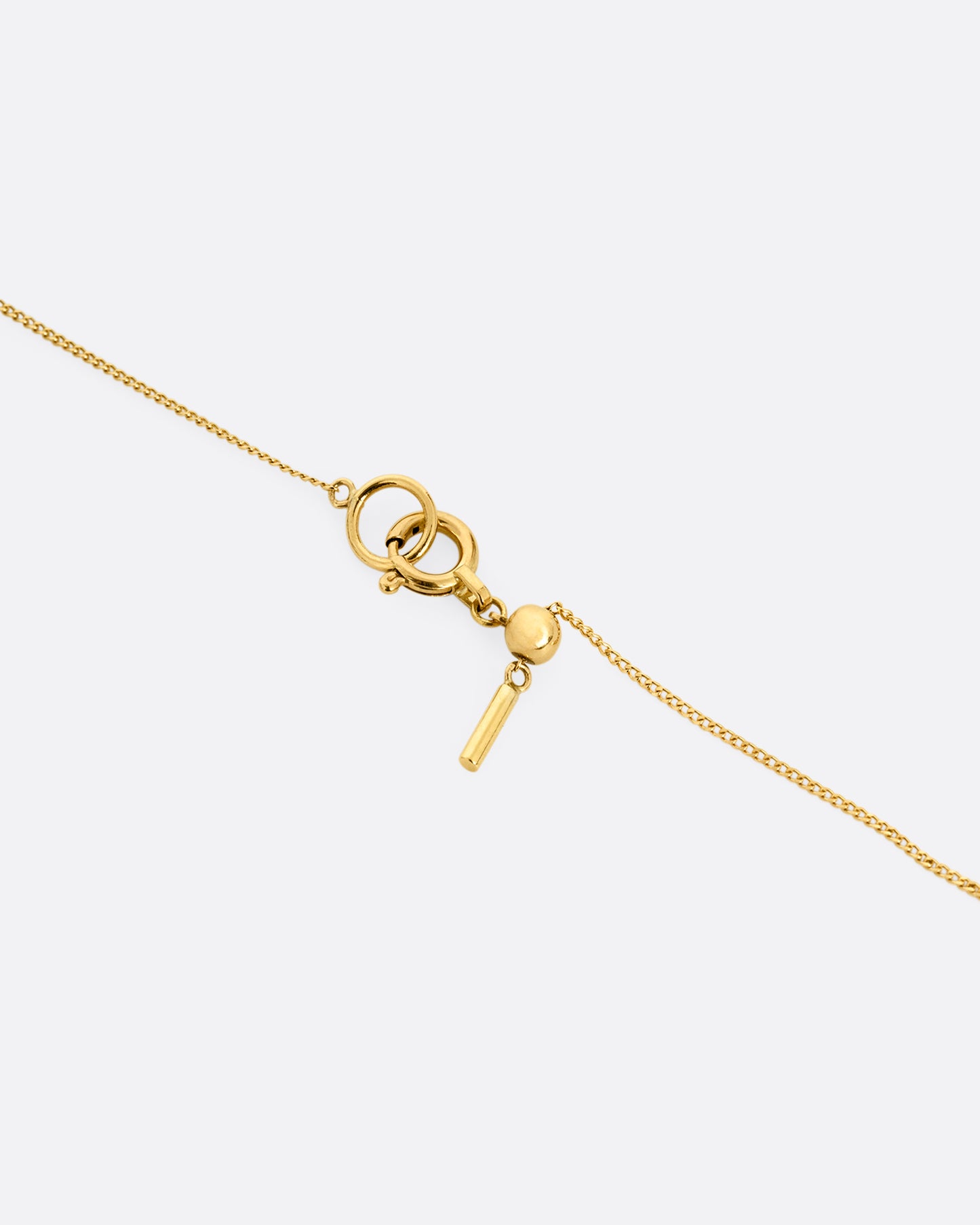 A close up of a yellow gold cable chain necklace clasp.