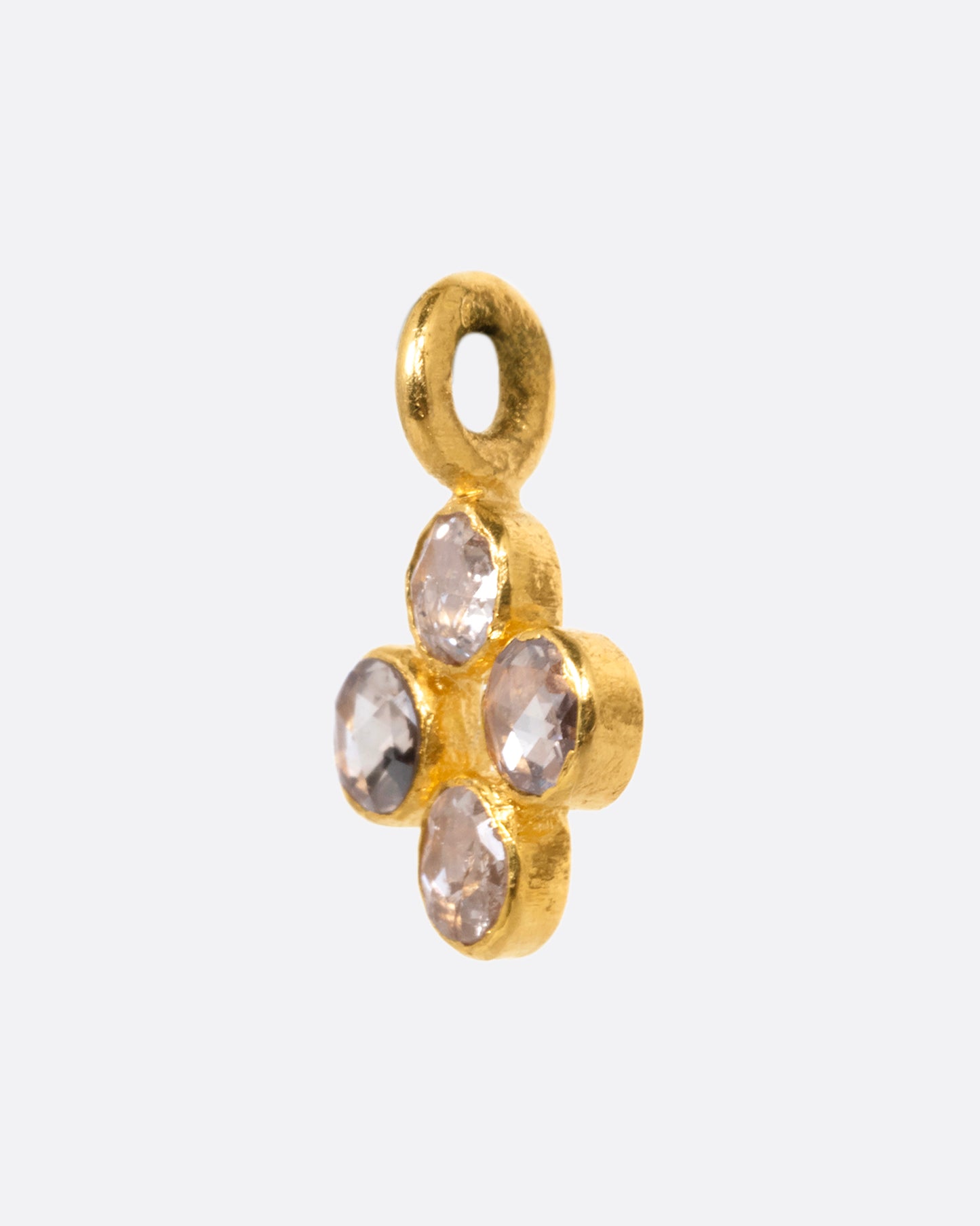 A yellow gold cross shaped charm with four diamonds. Shown from the side.