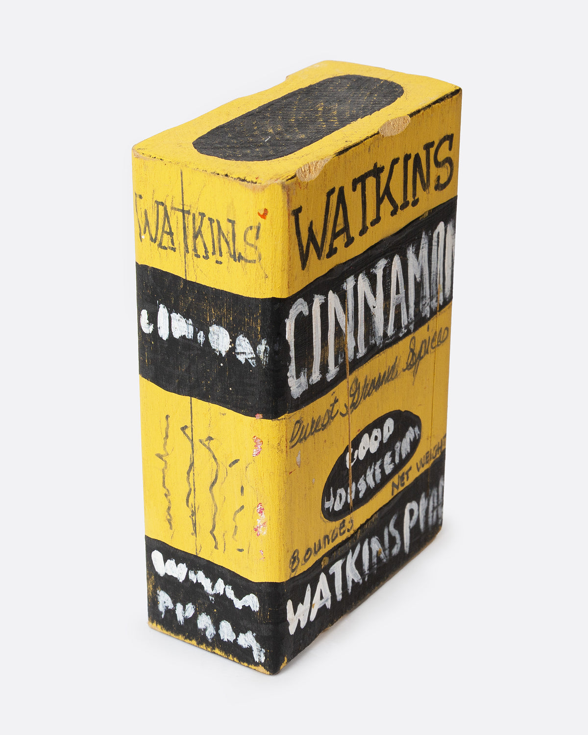 A yellow and black hand painted wooden box with the text 'WATKIN'S CINNAMON', shown from the side.