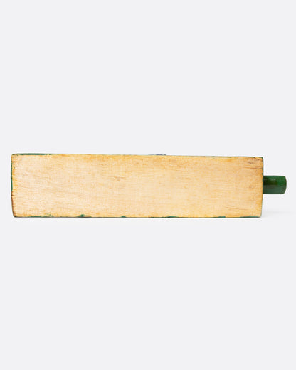 A wooden folk art toy with a yellow and blue woodpecker on a green base shown from the bottom.