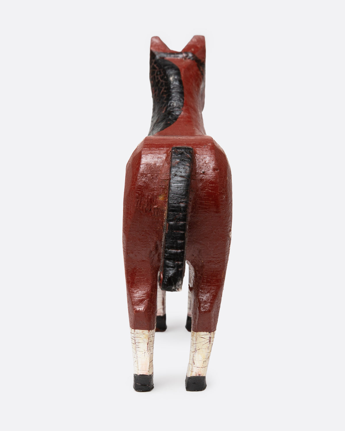 A hand painted and carved wooden bay horse, shown from the back.