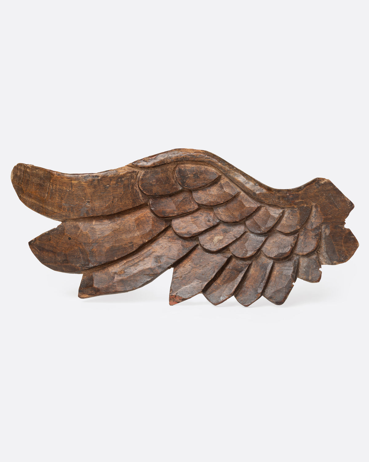 A wooden hand carved wing, shown from the front.
