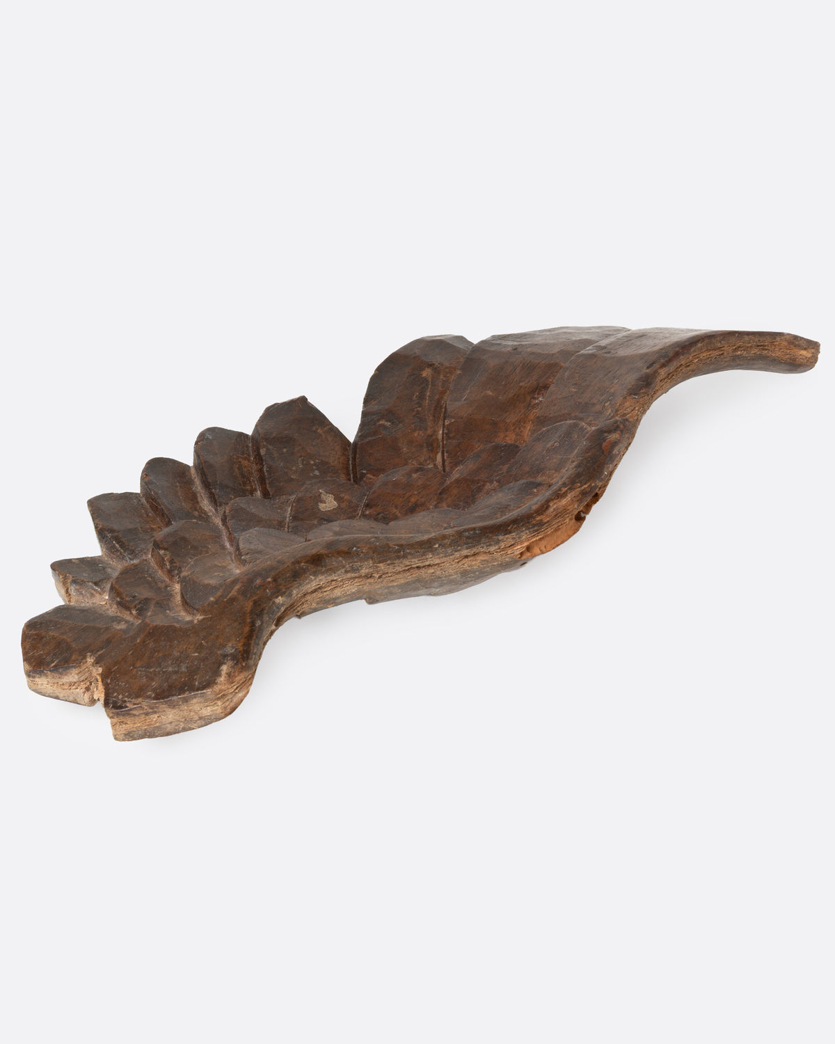 A wooden hand carved wing, shown from the back.