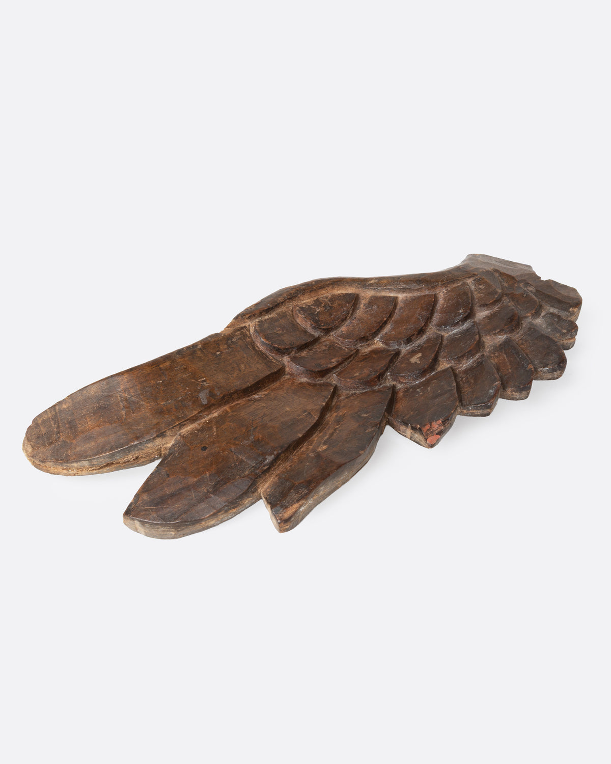 A wooden hand carved wing, shown from the side.