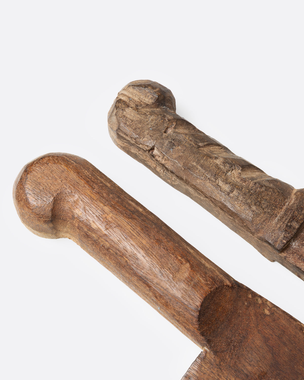 A close up of the handles of a hand carved wooden knife and cleaver set.