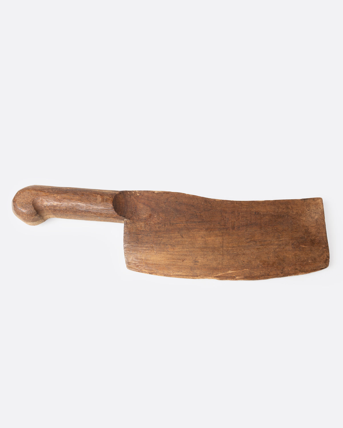 A hand carved wooden cleaver, shown from the side.