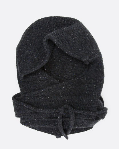 A donegal flecked charcoal hooded scarf with elongated sides, shown wrapped and tied, from the front.