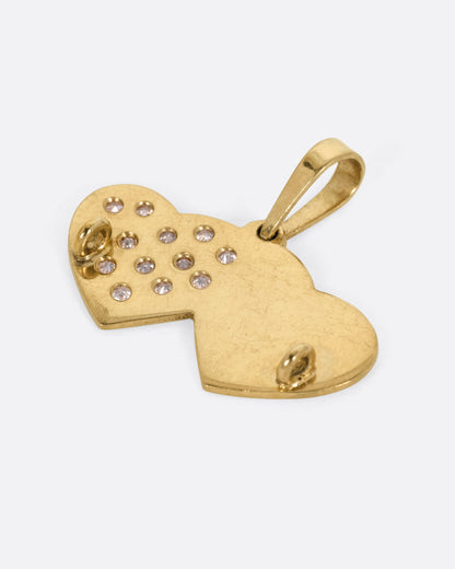 A yellow gold double heart charm with pavé diamonds over a stipple finish on one heart. Shown from the back.