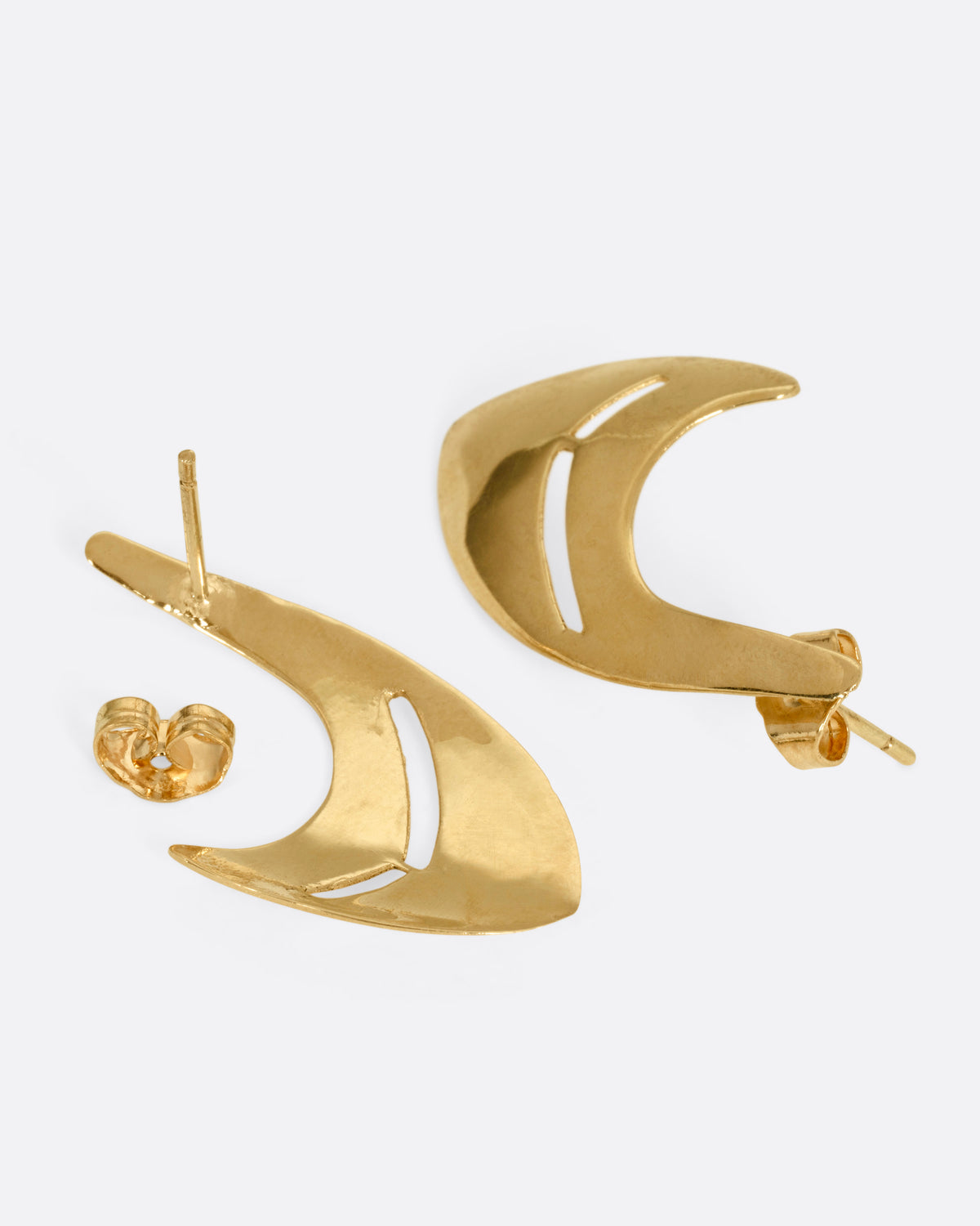 A pair of yellow gold curved earrings with cutouts. One earring is shown from the front, the other open from the back.