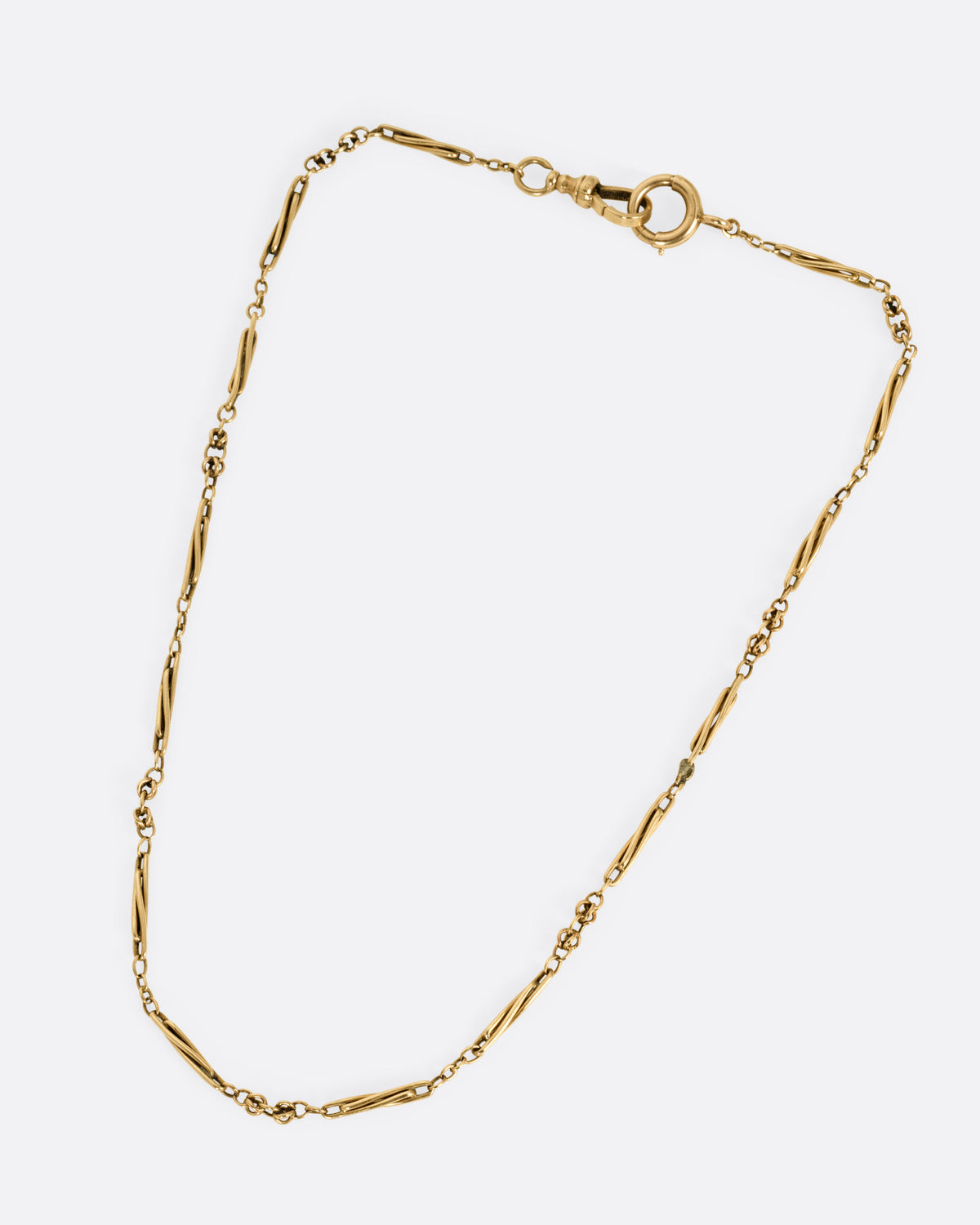 A yellow gold watch chain necklace with long twisted links, shown from the front.