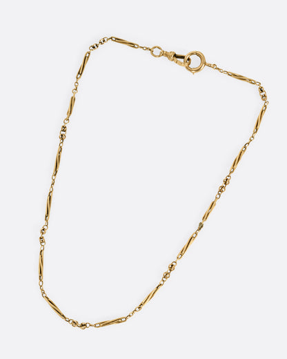 A yellow gold watch chain necklace with long twisted links, shown from the front.