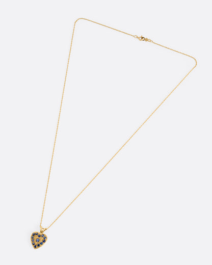 A yellow gold necklace with a heart shaped pendant with blue sapphires, shown from the front.