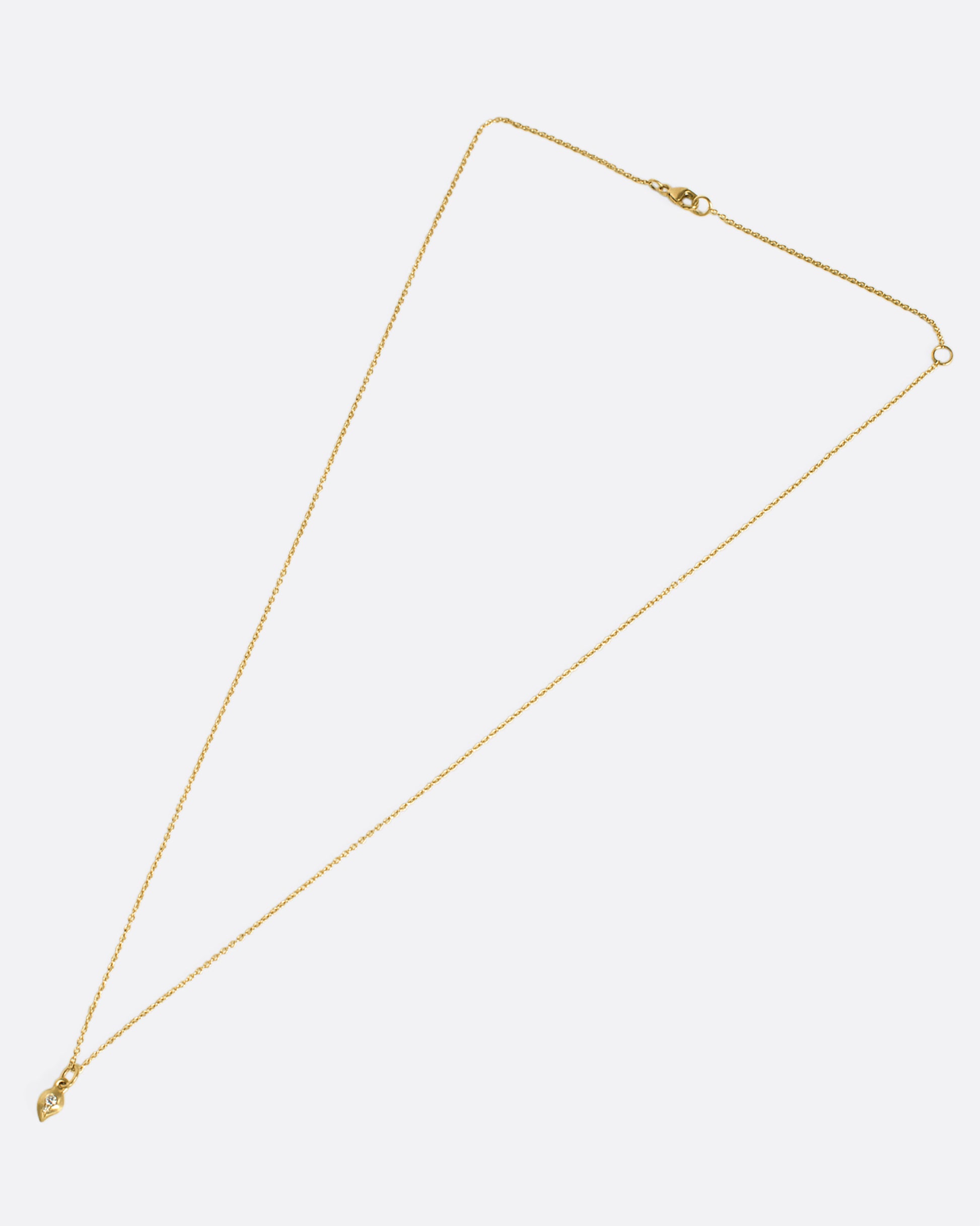 This delicate 10k gold necklace features two diamonds sparkling in a gold droplet