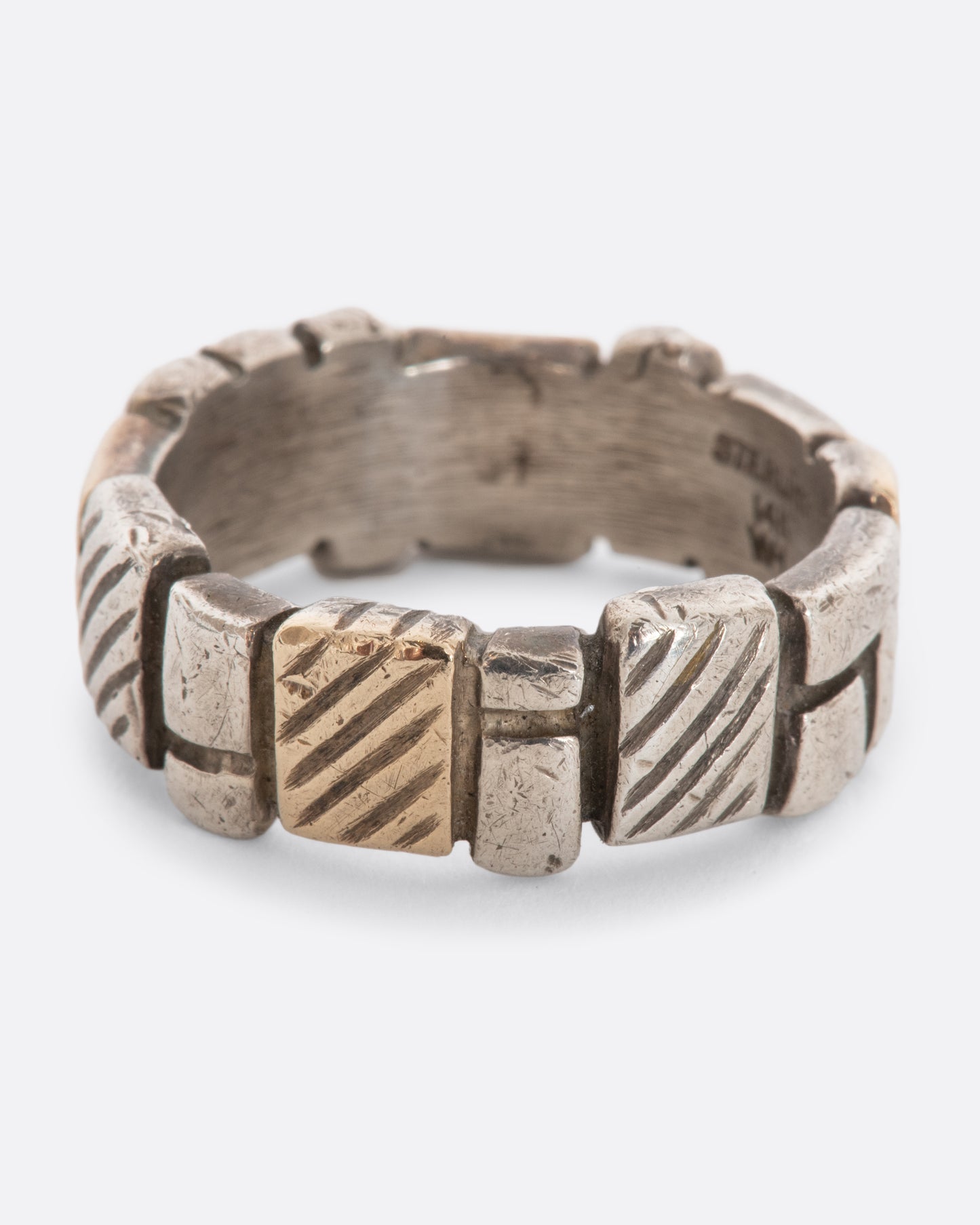 A textured sterling silver and yellow gold band with squares all around. 