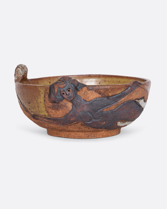 A ceramic studio pottery bowl with three dimensional nude women linking hands around the bowl. View one.