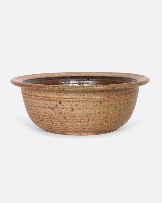 A ceramic lipped bowl with a painted interior. View from the front.