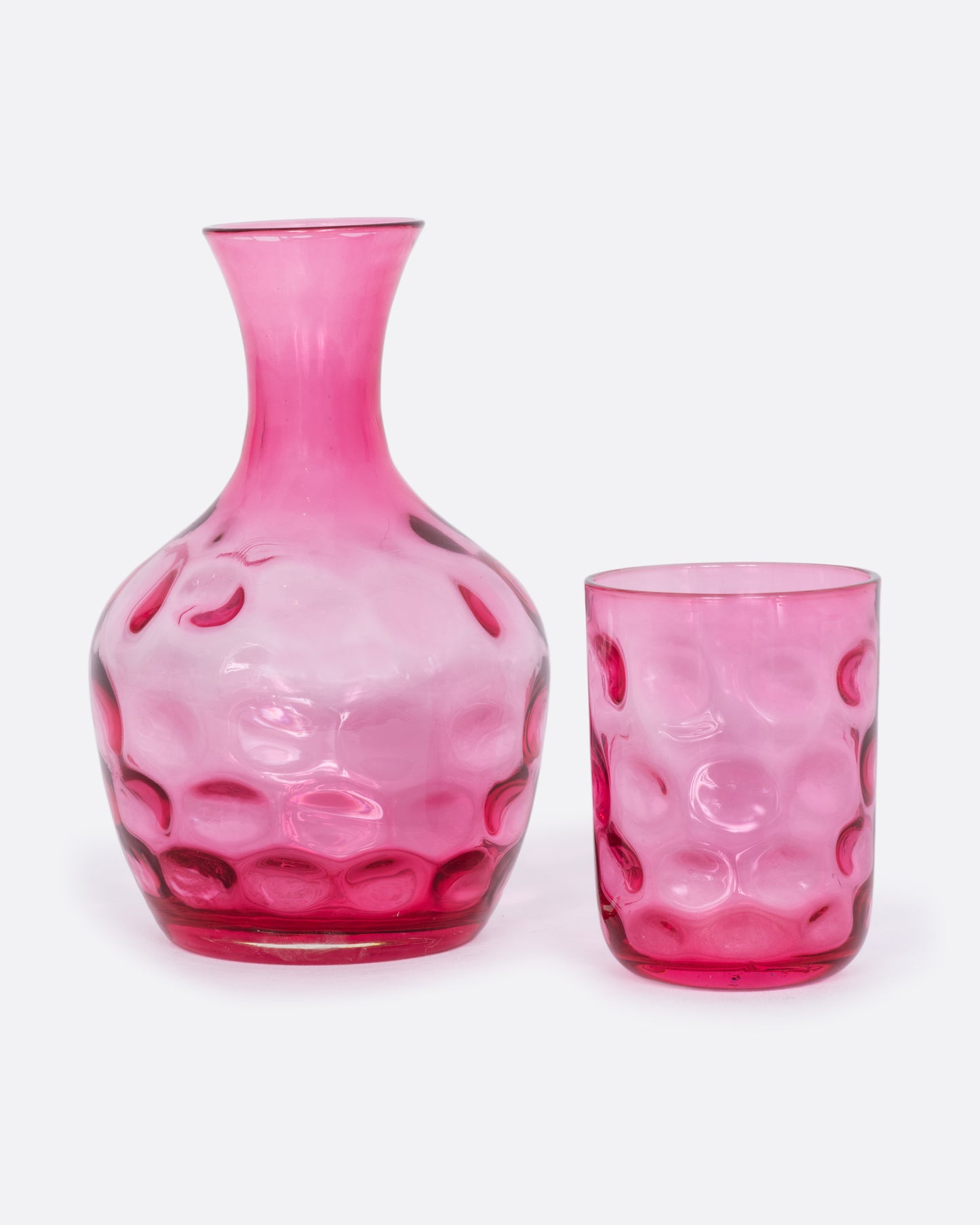 Pink dimpled glass decanter and cup set. 