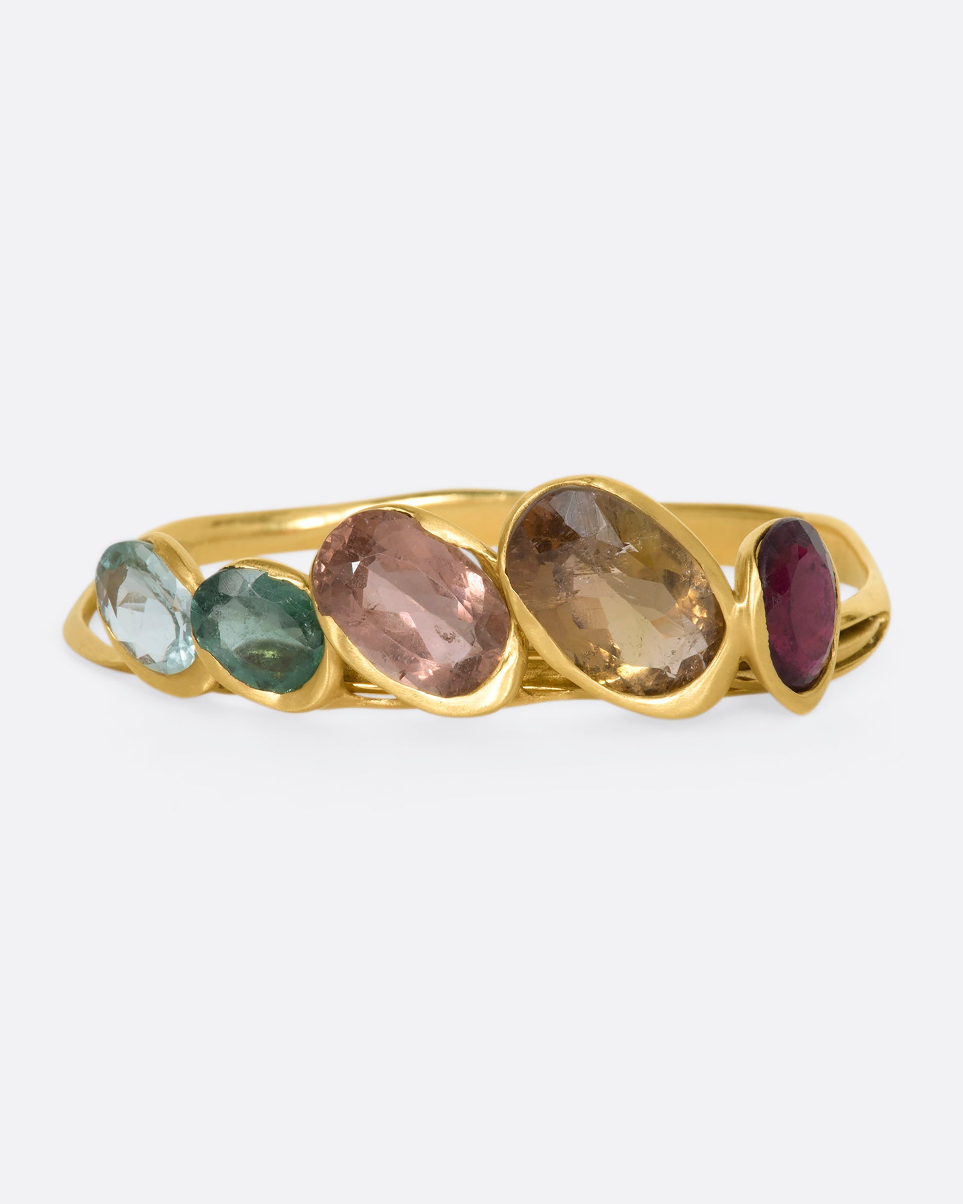 A yellow gold hinged bracelet crowned with five large different color tourmalines. View from the front.