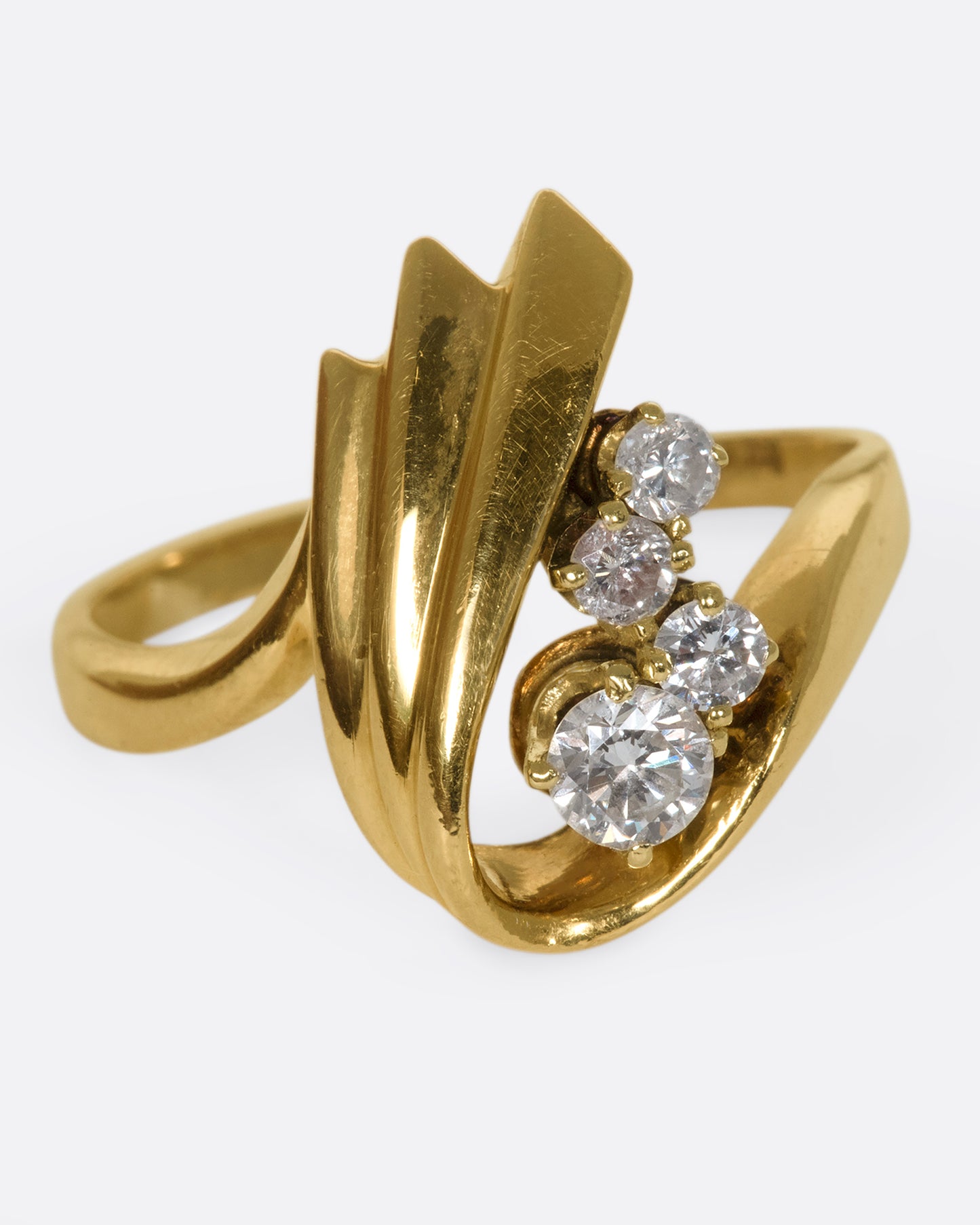 A vintage 14k gold U-shaped ring with four round diamonds resting in the center.
