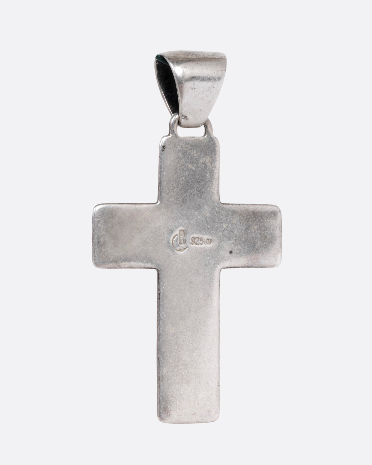 A silver cross with colorful inlay, shown from the back.