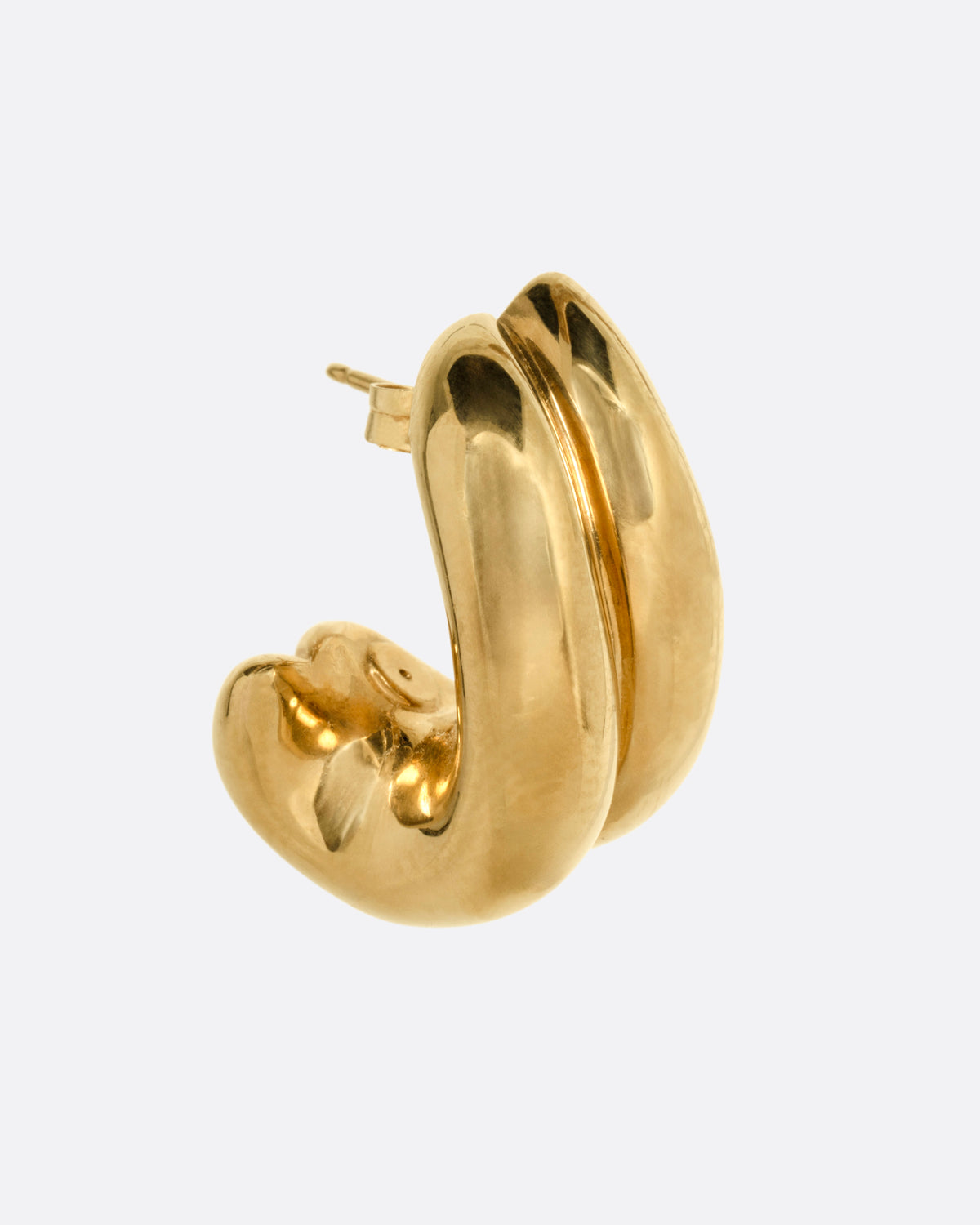 A yellow gold curved huggie earring, shown from the side.