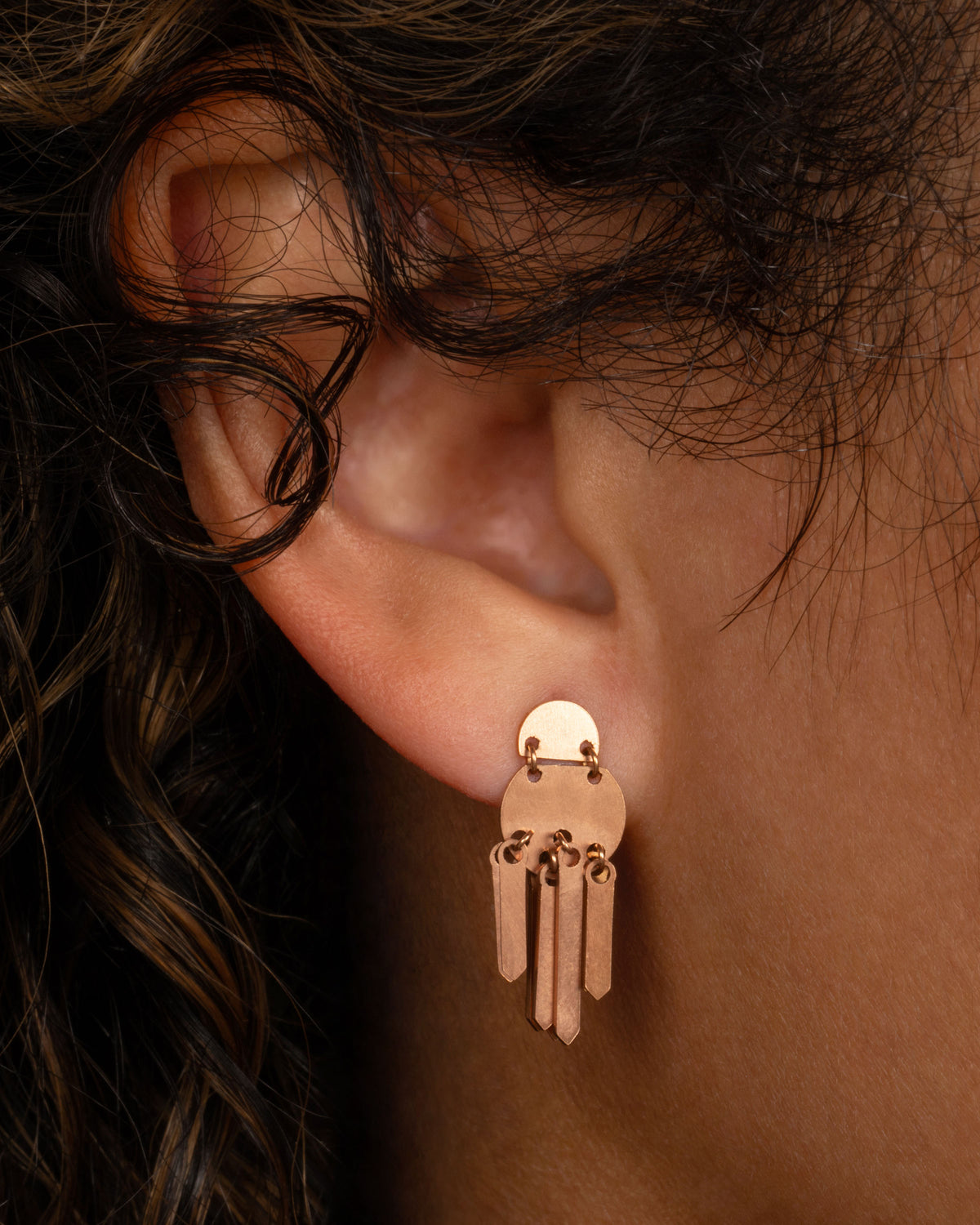 Lori Leven Double Dot fringe earring in rose gold worn on an ear, two stacked half-circle discs with a fringe of flat gold sticks