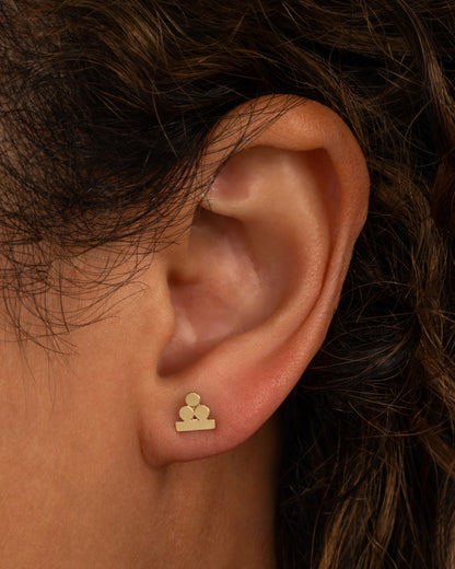 Rose gold stacked circles stud earring worn on an ear