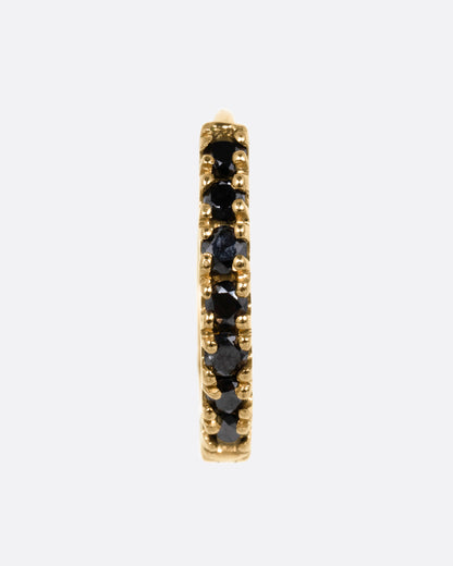 A yellow gold hinged hoop earring with black pavé diamonds, shown from the front.