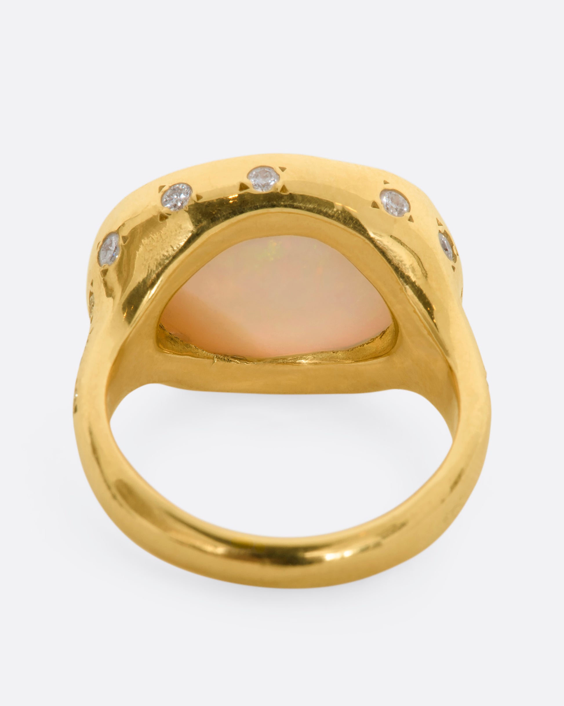 A polished yellow gold ring with a large east west oval Australian opal and diamonds on the setting and shoulders. View from the back.