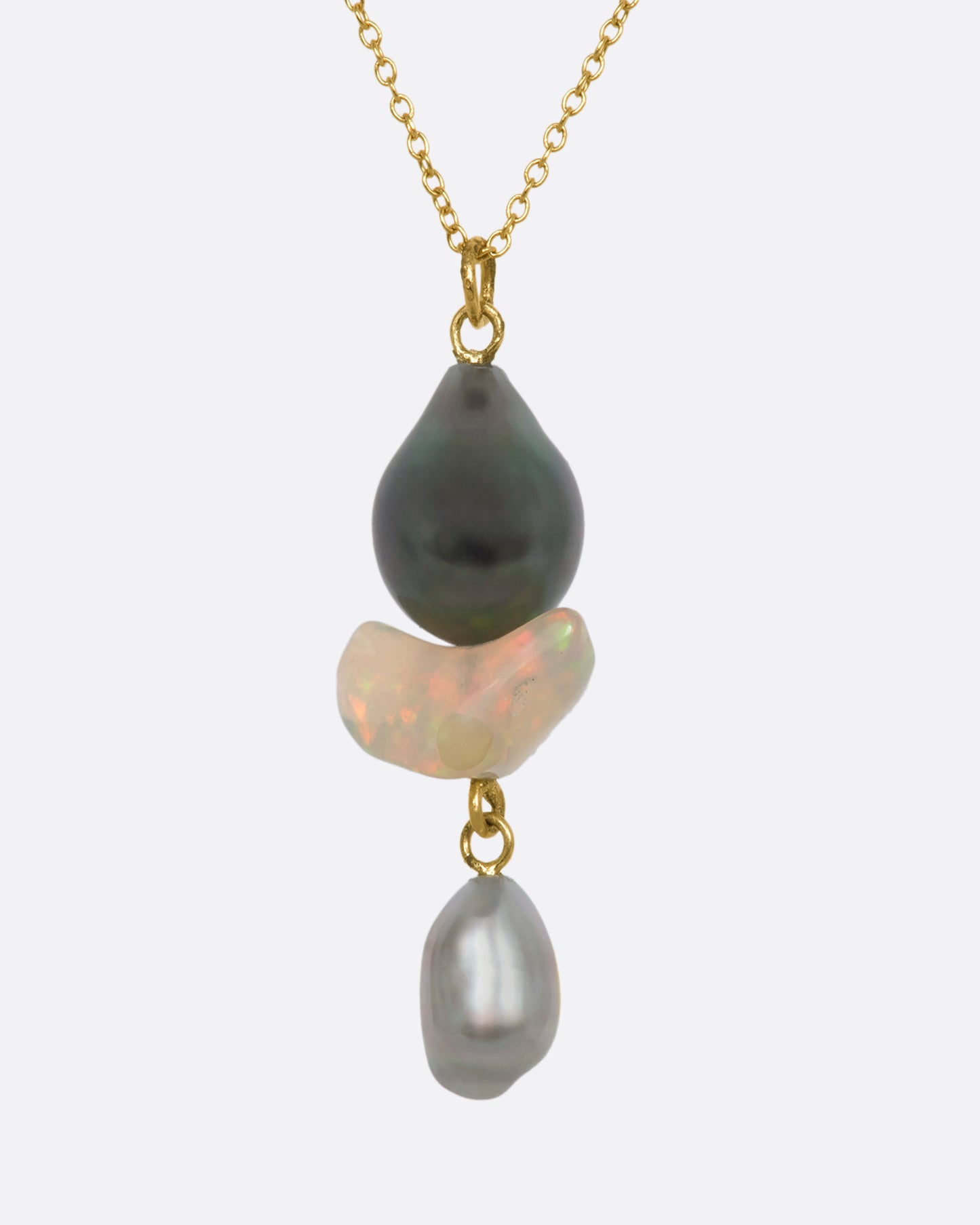 A yellow gold necklace with a triple drop pendant consisting of one opal and two pearls. View from the front.