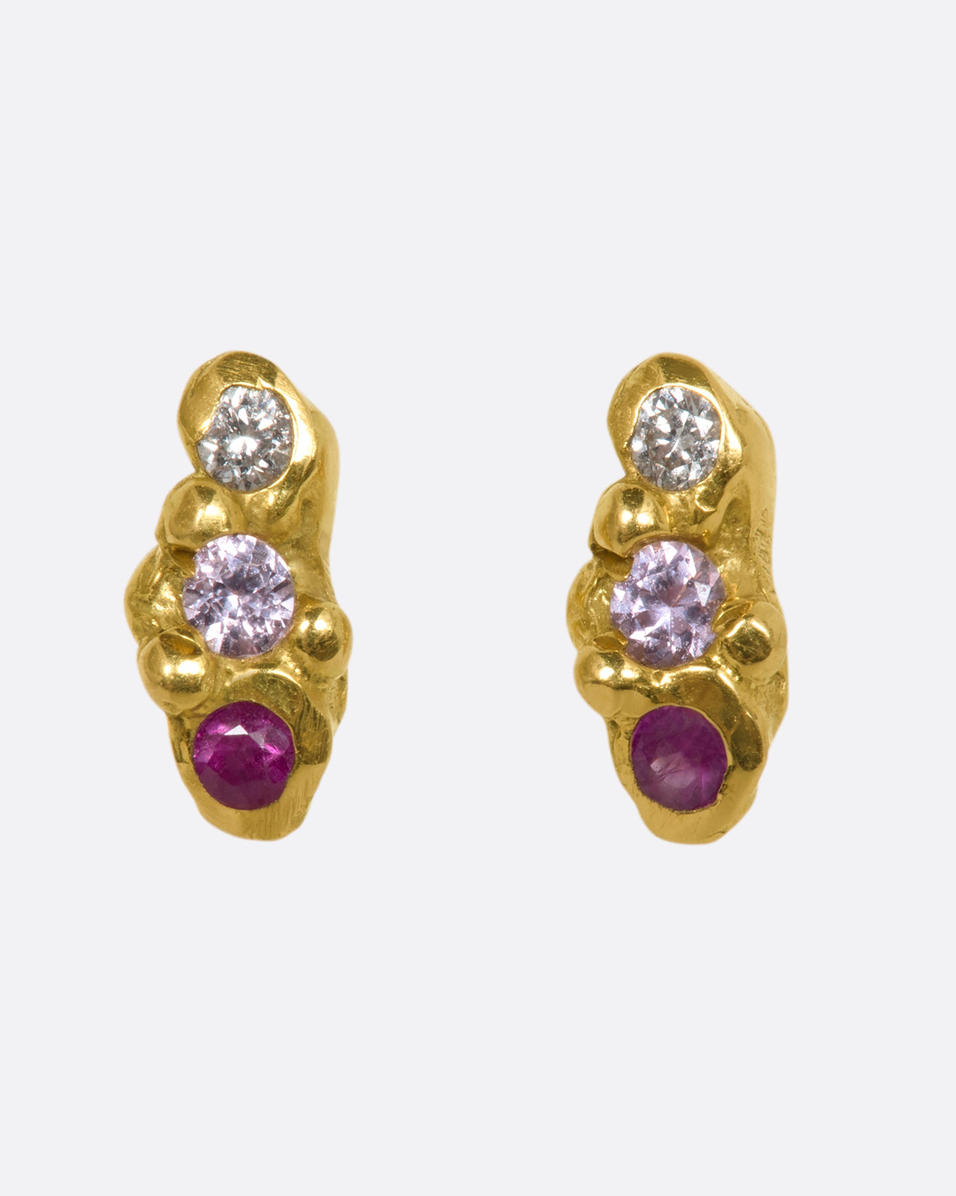 A pair of yellow gold bubble studs with diamonds, sapphires and rubies. Shown from the front.