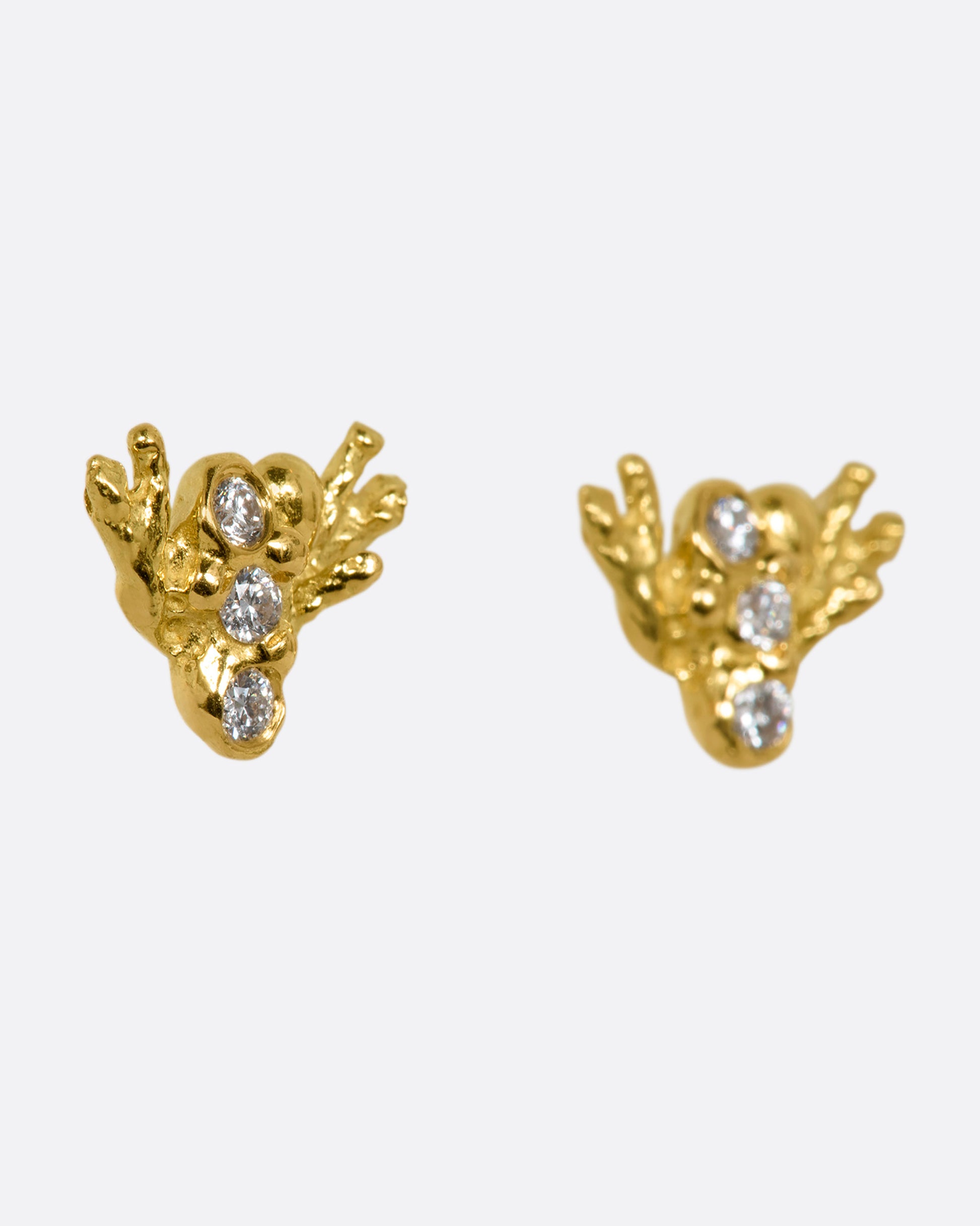 A pair of yellow gold studs abstractly shaped like a bee with diamonds. Shown from the side.