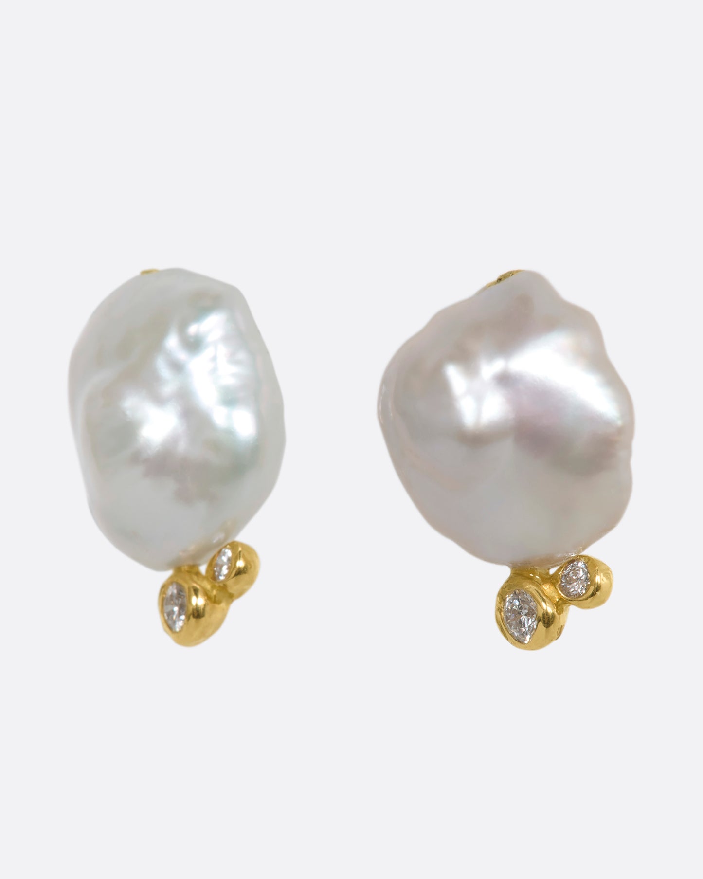 A pair of yellow gold studs with Keshi pearls and white diamonds. Shown from the side.