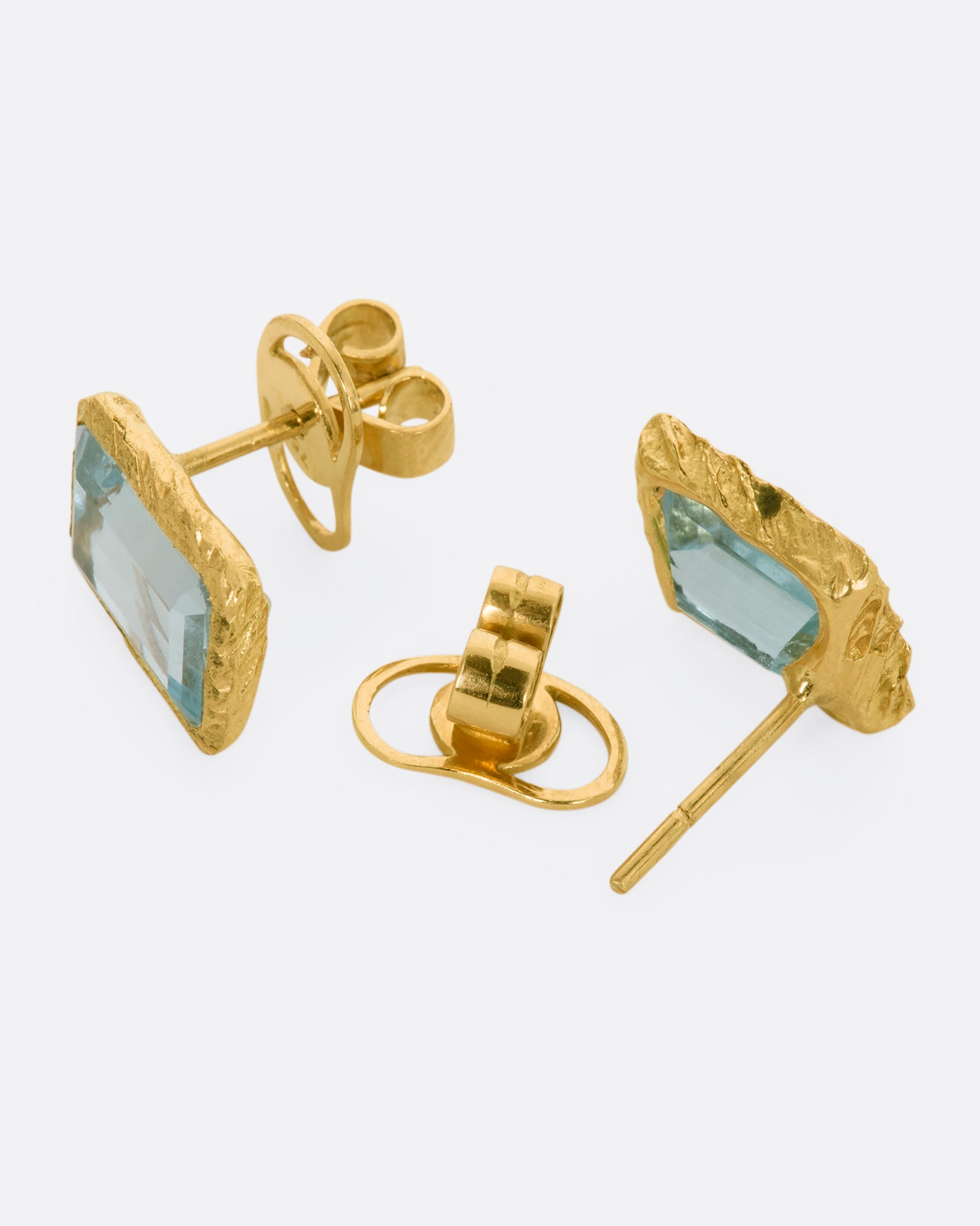 A yellow gold stud earrings with rectangular aquamarines. Shown from the front and back alternating.