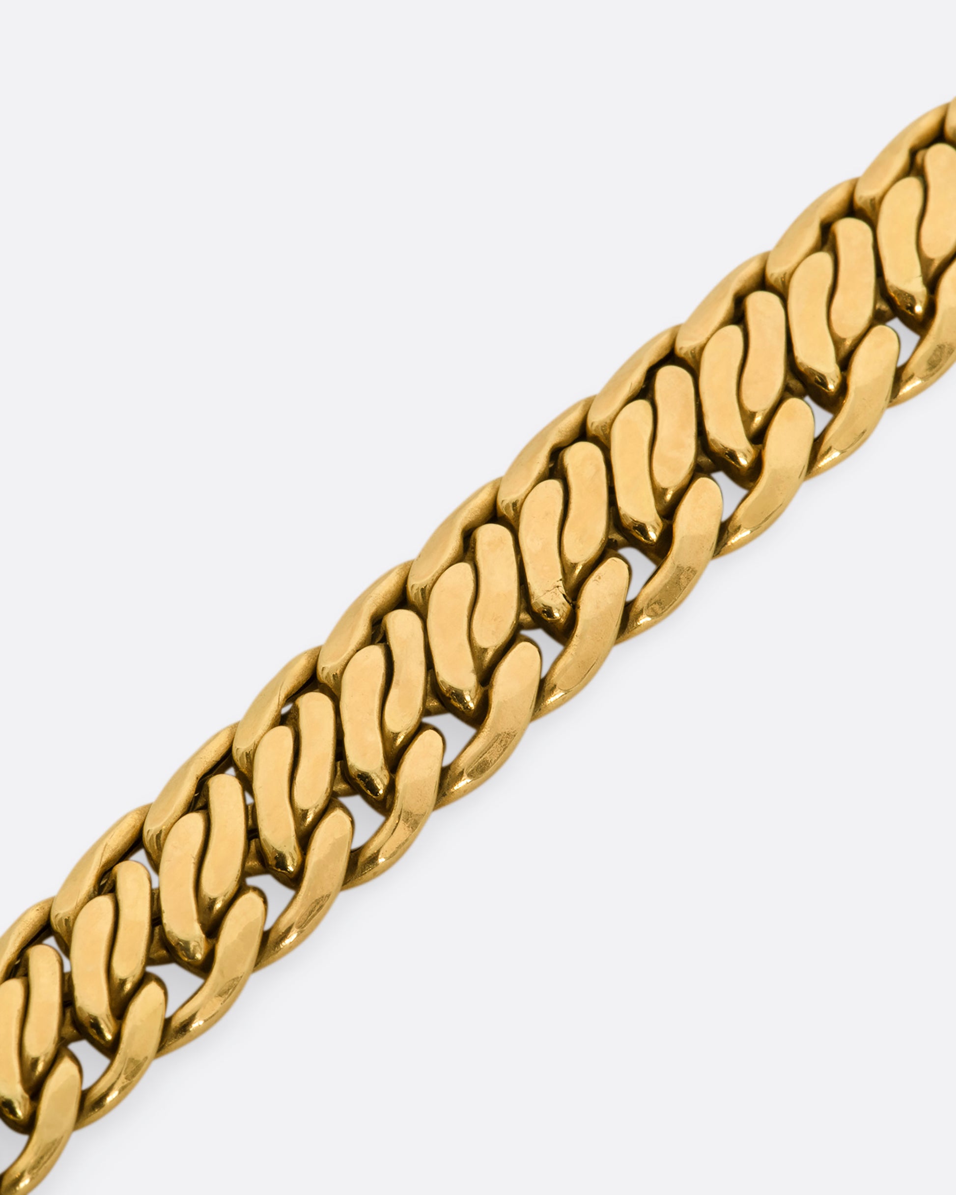 A yellow gold flat double curb chain necklace. View of the links up close.