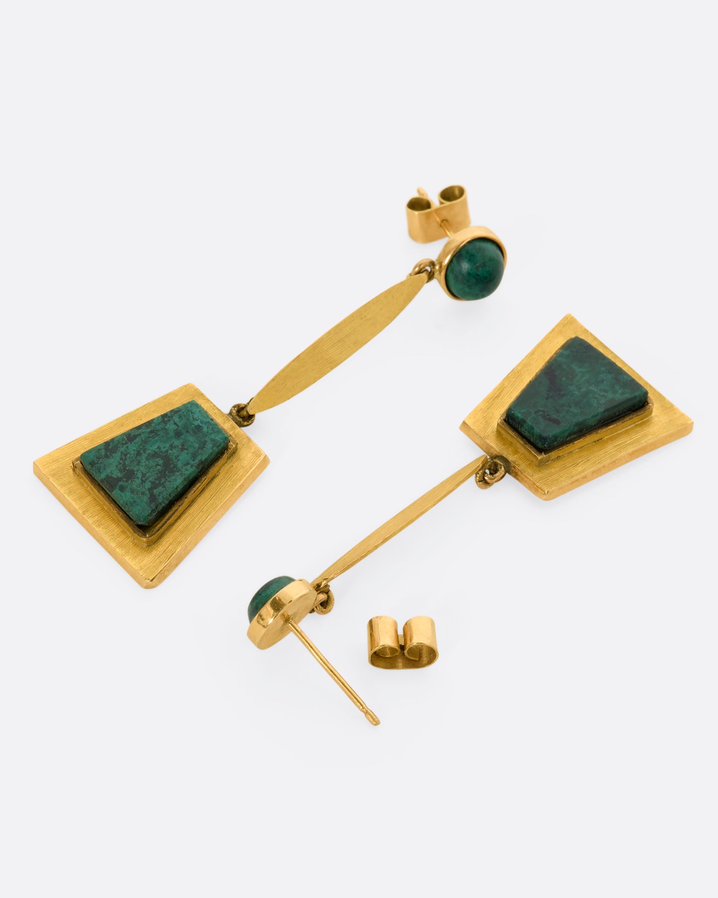 A yellow gold pair of trapezoid drop earrings with malachite. View laying flat.