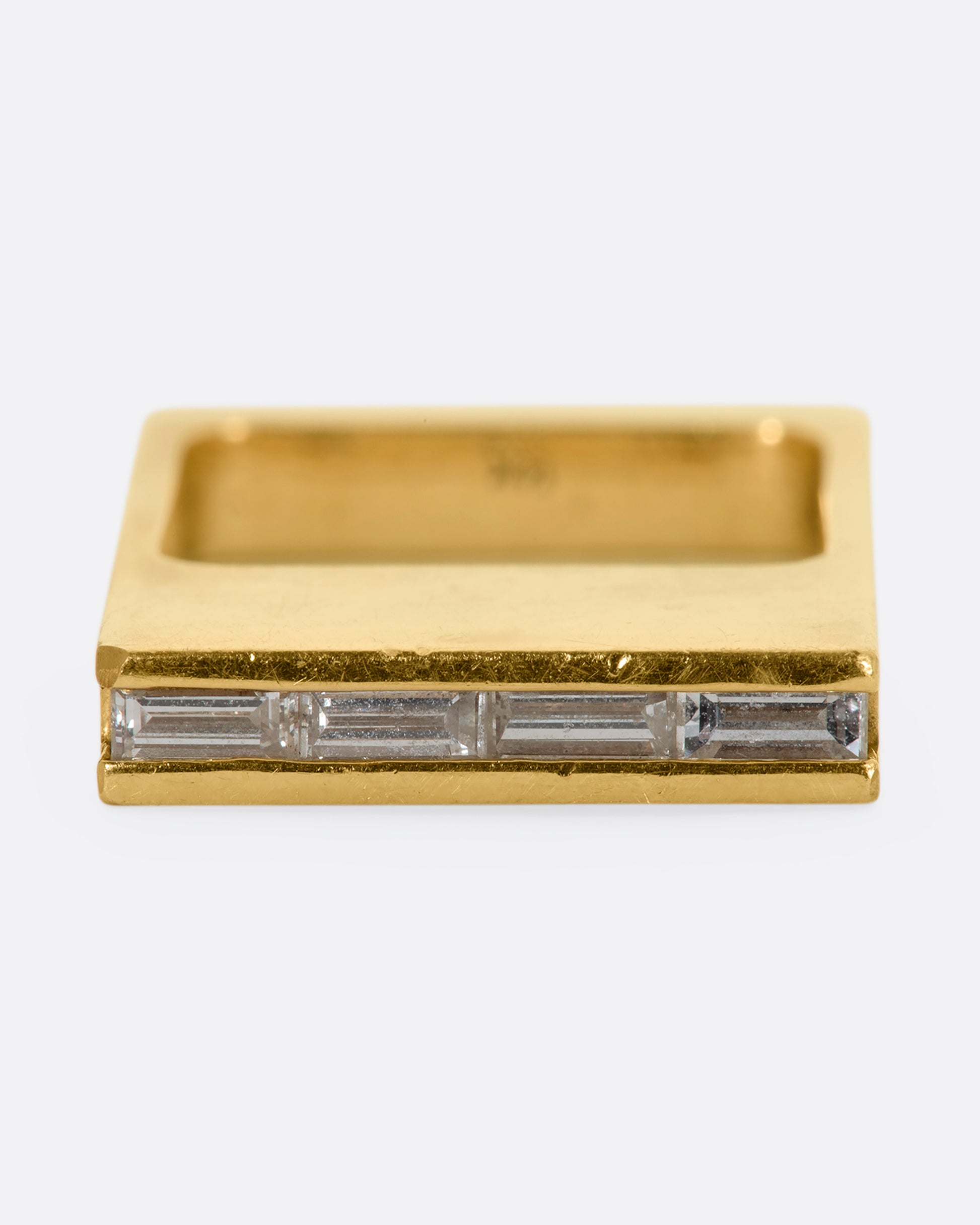 A yellow gold rectangle ring with channel set baguette diamonds. View from the front.