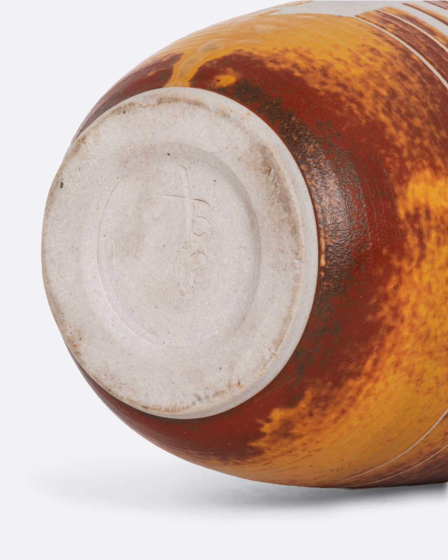 Golden yellow and brown ceramic vase with a sailboat. View of the bottom.