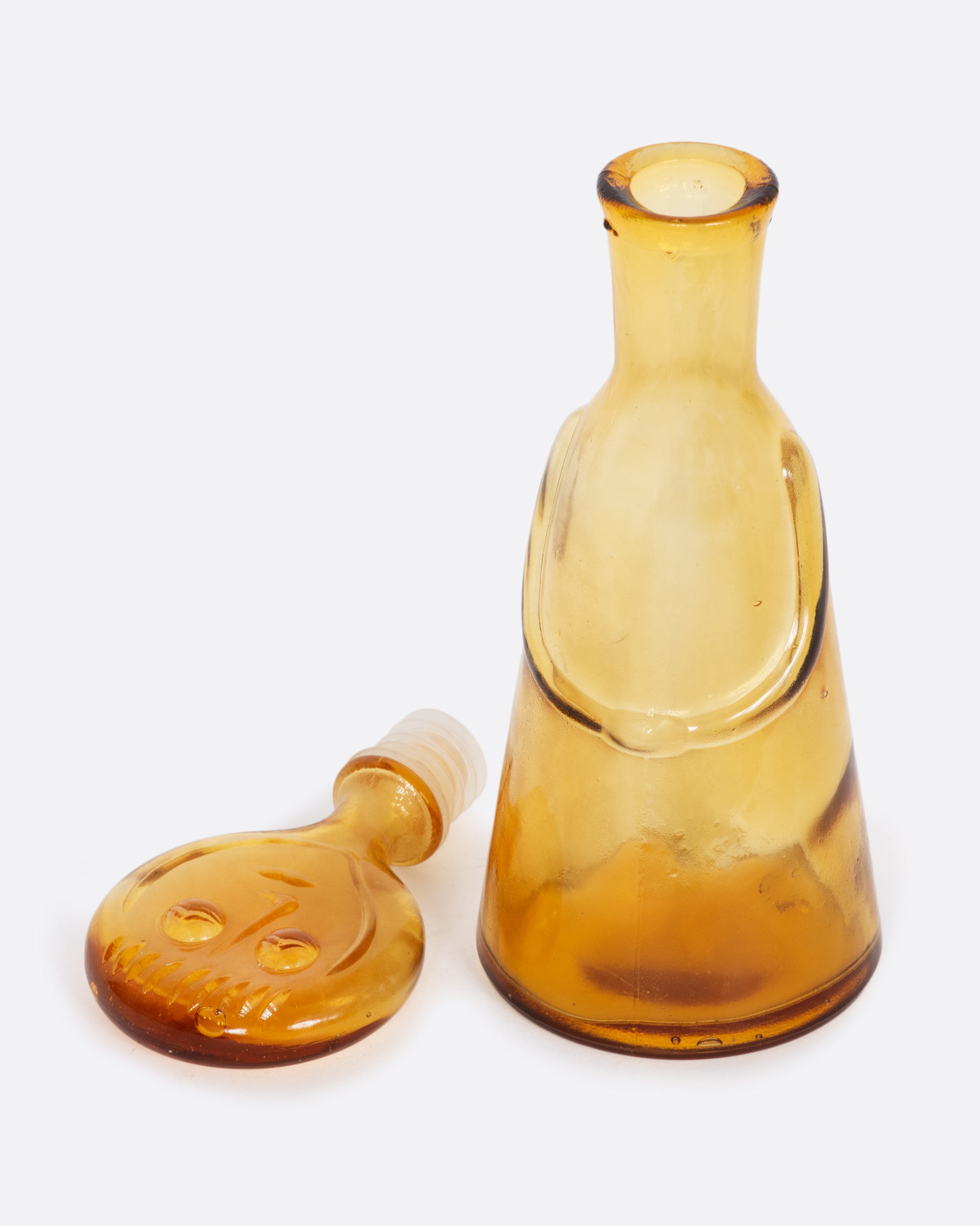 Clear yellow glass person decanter. View with the lid off.