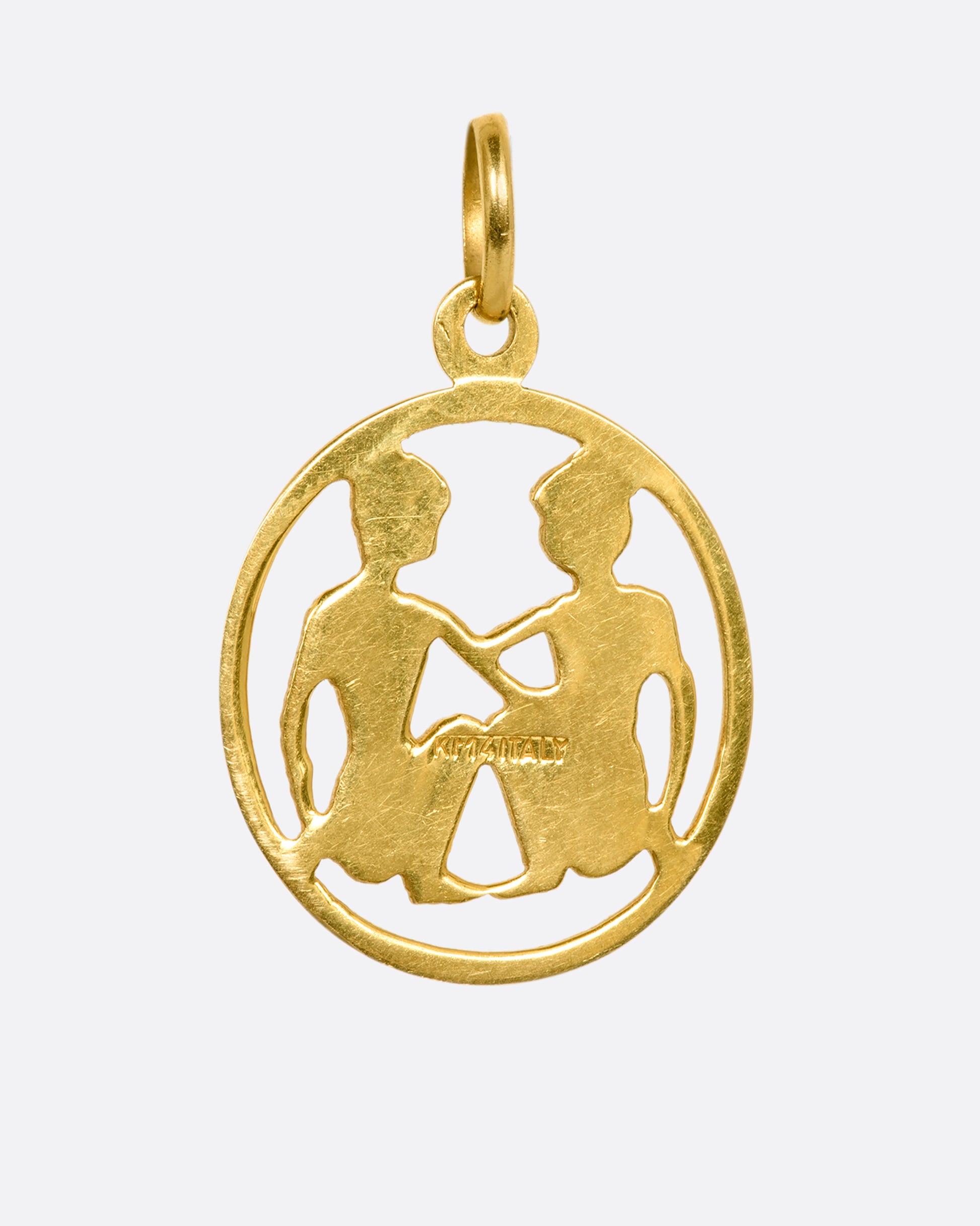 A yellow gold Gemini medallion charm or pendant. View from the back.