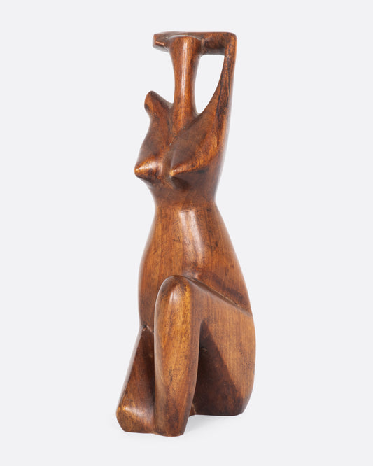 Wooden nude figure sculpture. View from the side.