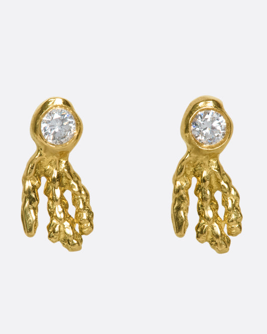 18k gold and diamond stud earrings that look like glowing sea creatures swimming across your ear