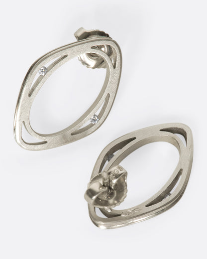 Vintage white gold diamond window stud earrings, the pair laid flat showing the posts and backs