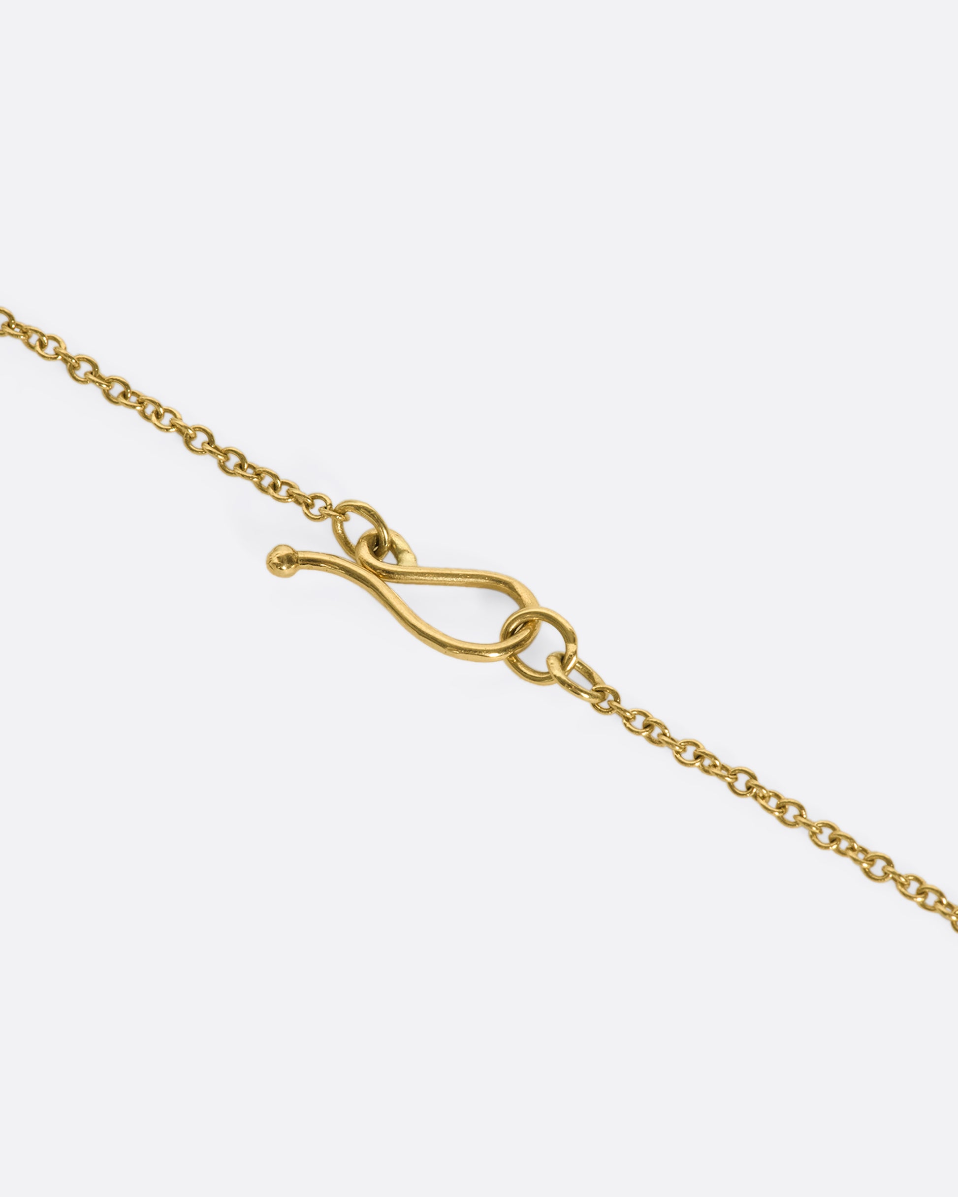 This 18k gold chain holds a unique watermelon rubellite heart encased in a gold bezel setting