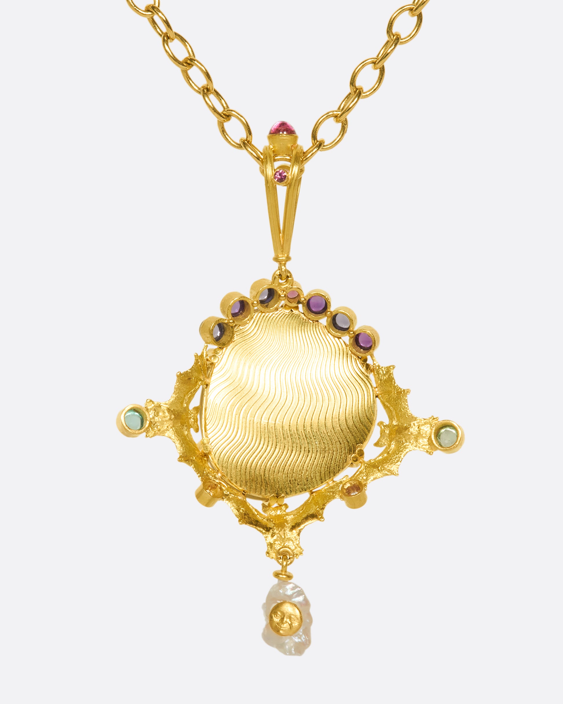 This incredible black opal pendant is held in place by three 18k gold bats and adorned with iolite, tourmaline, amethyst, natural pearl, and diamonds.