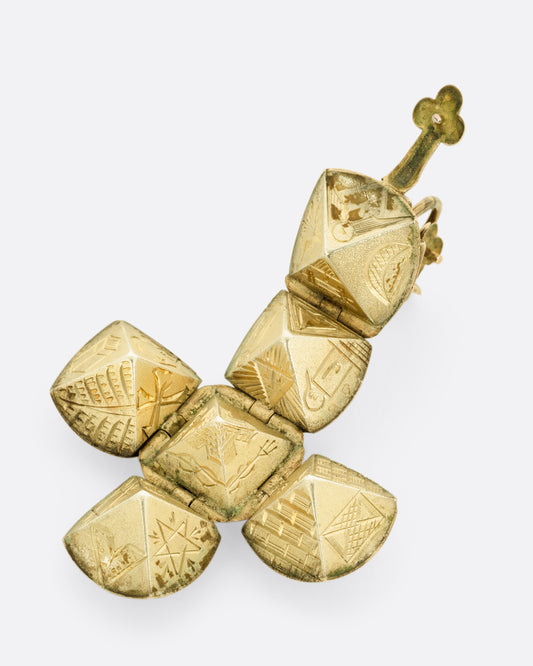 A yellow gold engraved Masonic Orb pendant shown open in a dimensional cross shape. 