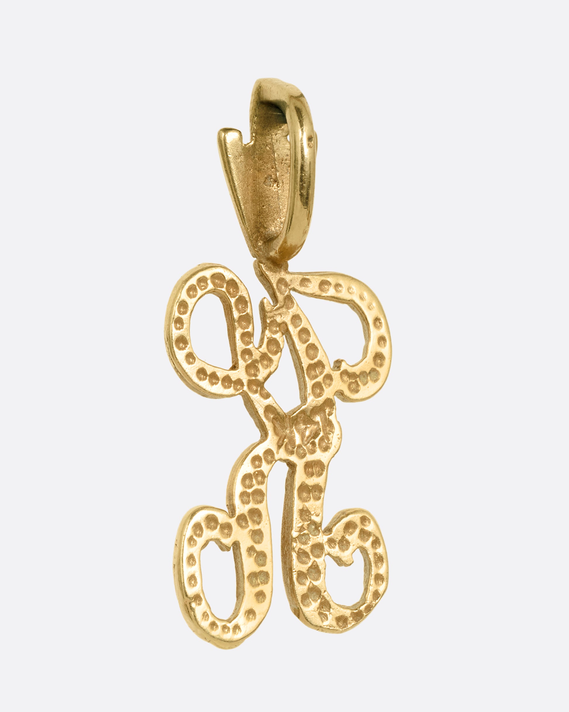 A curling initial 'K' charm, shown from the back.